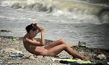 Dark-haired nude chick walking around naked on a beach