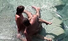 Krásná brunetka v odstínech ukazuje své nahé tělo na nudistické pláži